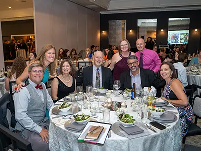 Guests sit around half a table