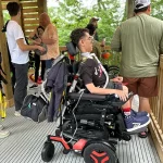 Boy in wheelchair waiting with friends