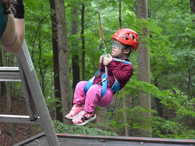 A boy dangling from a zip line