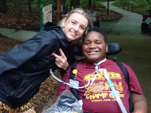 A boy and counselor smile for the camera