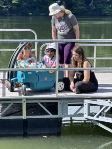 Three counselors and a camper on the dock