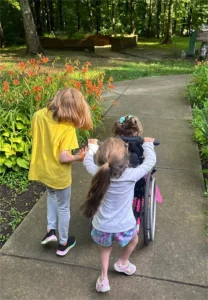 Three campers going down a sidewalk